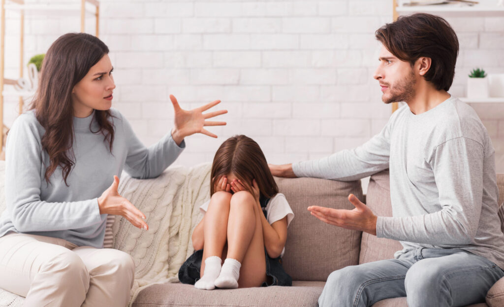 Streitende Eltern, Kind sitzt mittig dazwischen